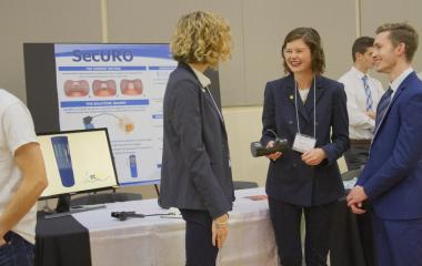 Students laugh in front of their inventure prize poster boards