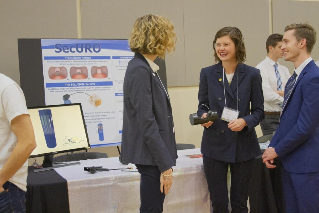 Students laugh in front of their inventure prize poster boards