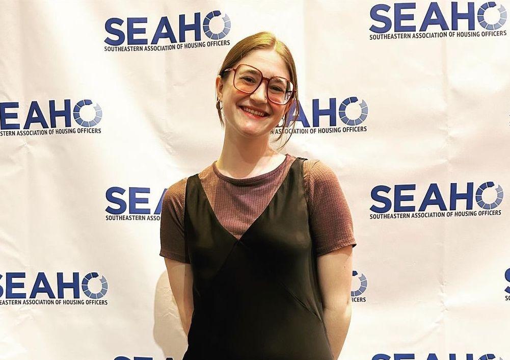 jordan howell honors program student in front of a backdrop